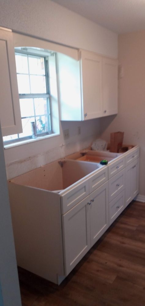 White shaker kitchen cabinets being installed